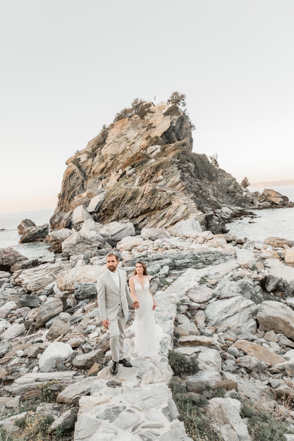 Wedding photos on dramatic rocky coastal cliffs at sunset.