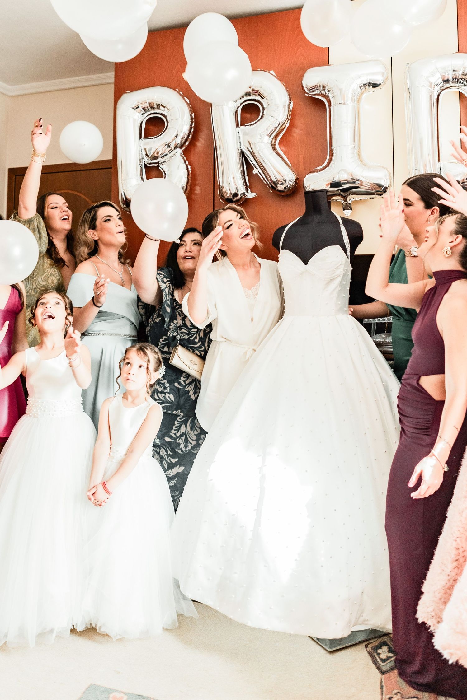 Joyful wedding party celebration with bridesmaids in formal dresses.
