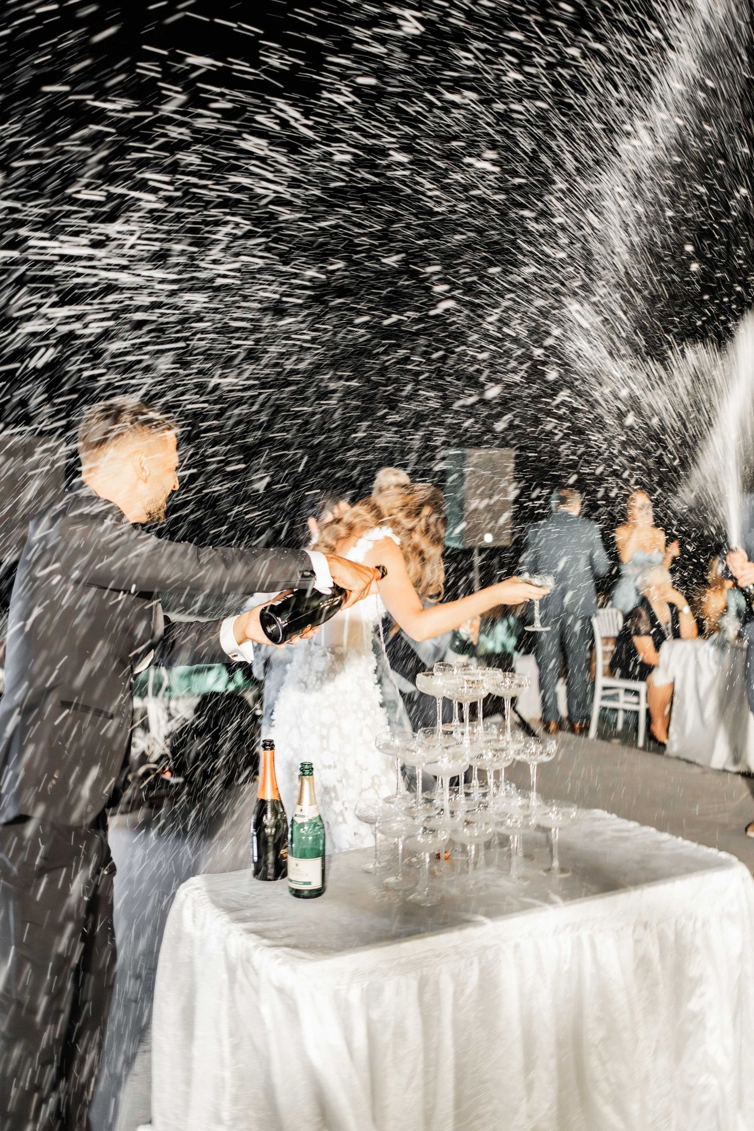 Champagne spray celebration creates dramatic effect at wedding reception.