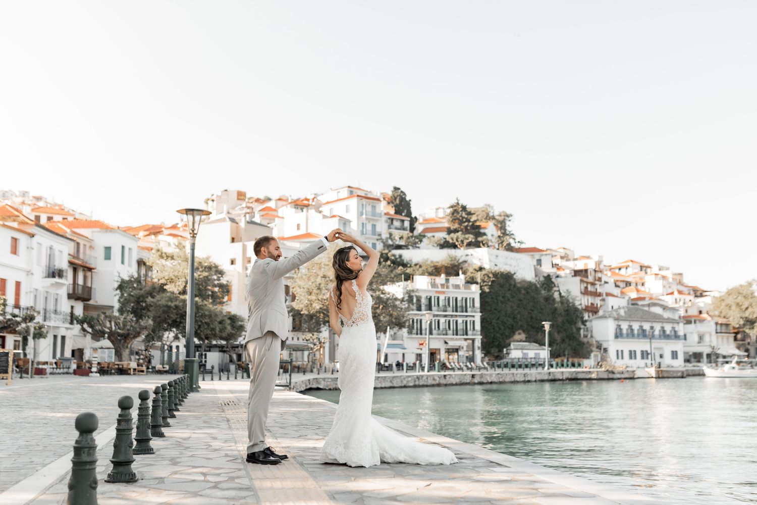 Panoramic view of coastal wedding venue with white buildings along waterfront.