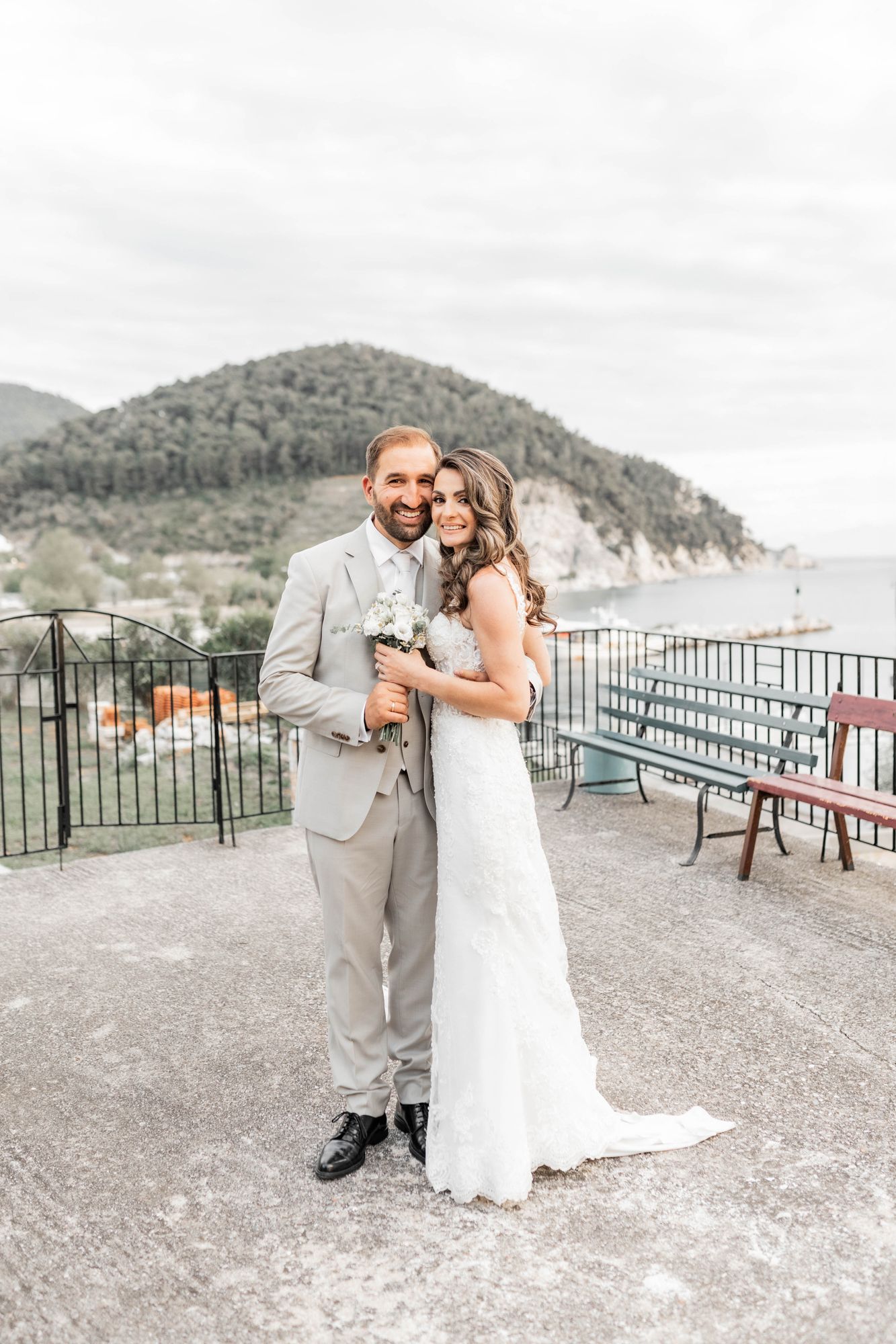 Newlyweds share romantic moments on a scenic mountain terrace overlooking the landscape.