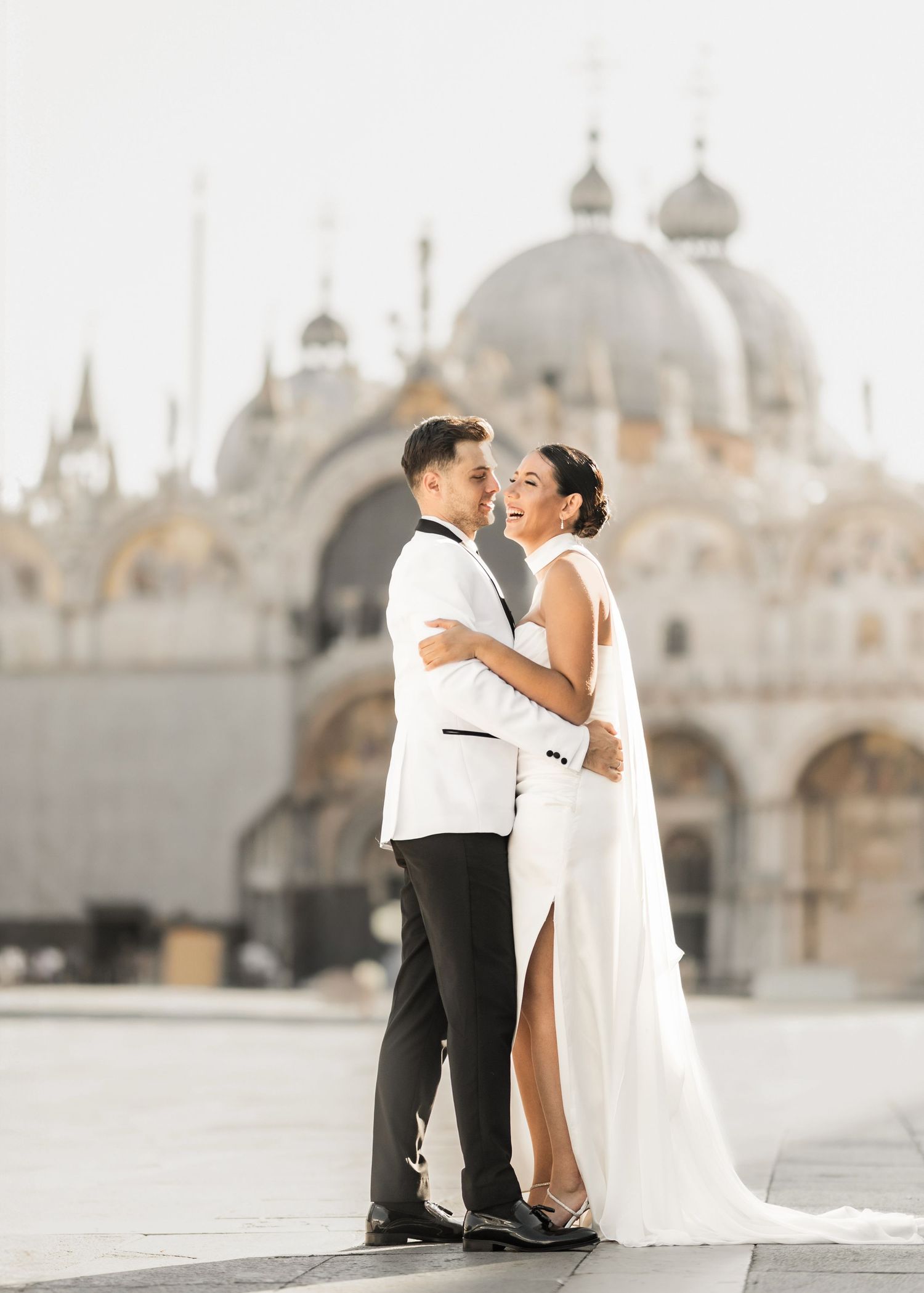 Wedding couple sharing intimate moments in front of St. Mark's Basilica in Venice.