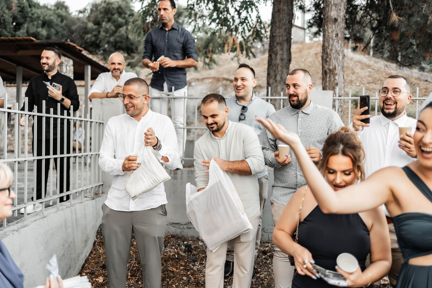 Groomsmen in gray suits pose together for candid celebration photos.