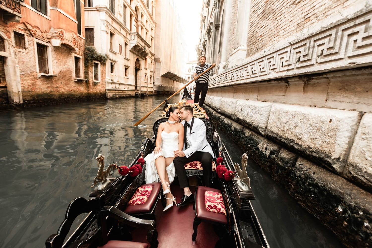 Scenic gondola ride through narrow Venetian canals during a wedding photoshoot.