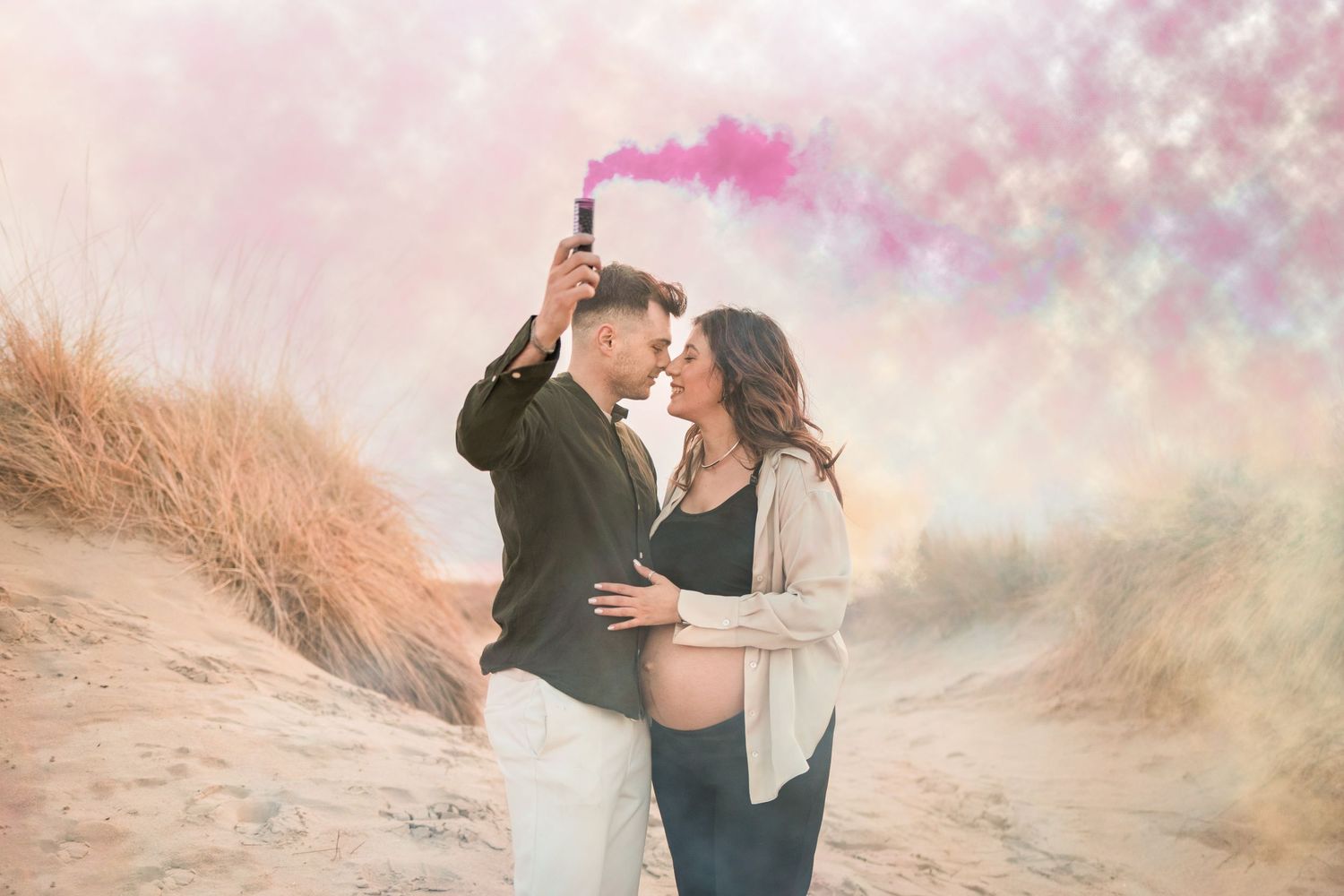 A romantic couple embraces on a sandy beach path with dreamy pink and golden sunset lighting in the background.