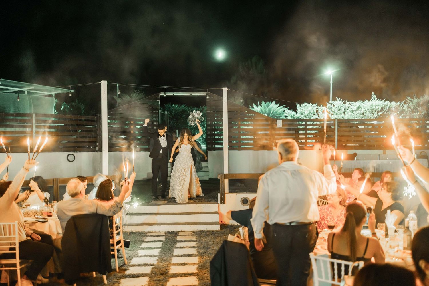 Wedding sparkler exit creates magical light trails in the dark evening celebration.