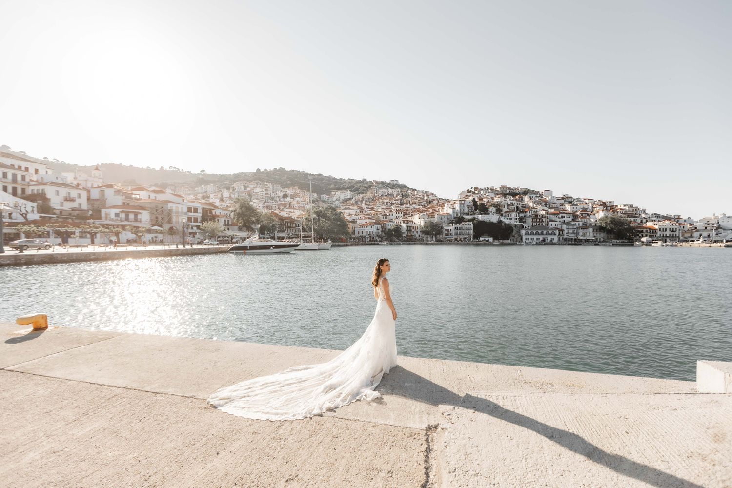 Scenic waterfront location with white buildings and mountains in background.