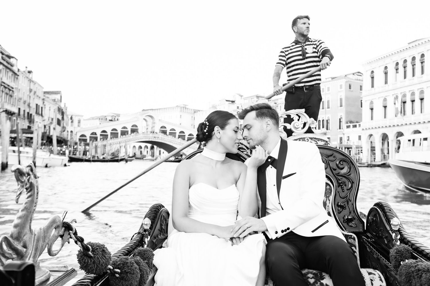 Black and white wedding photos capturing joyful moments along Venice's canals.