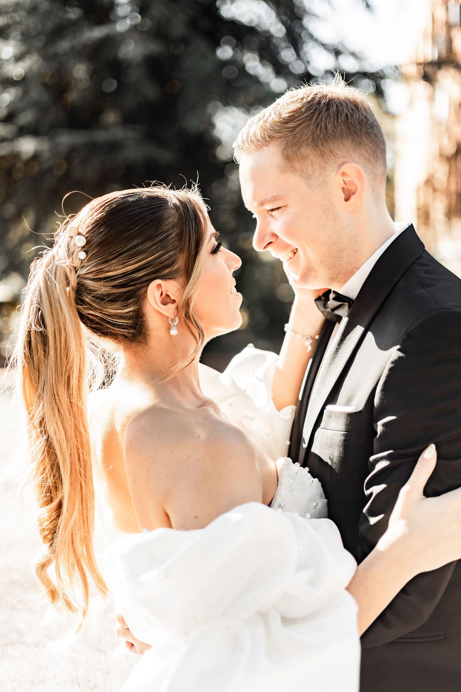 Intimate candid moment between newlyweds sharing laughter in golden sunlight.