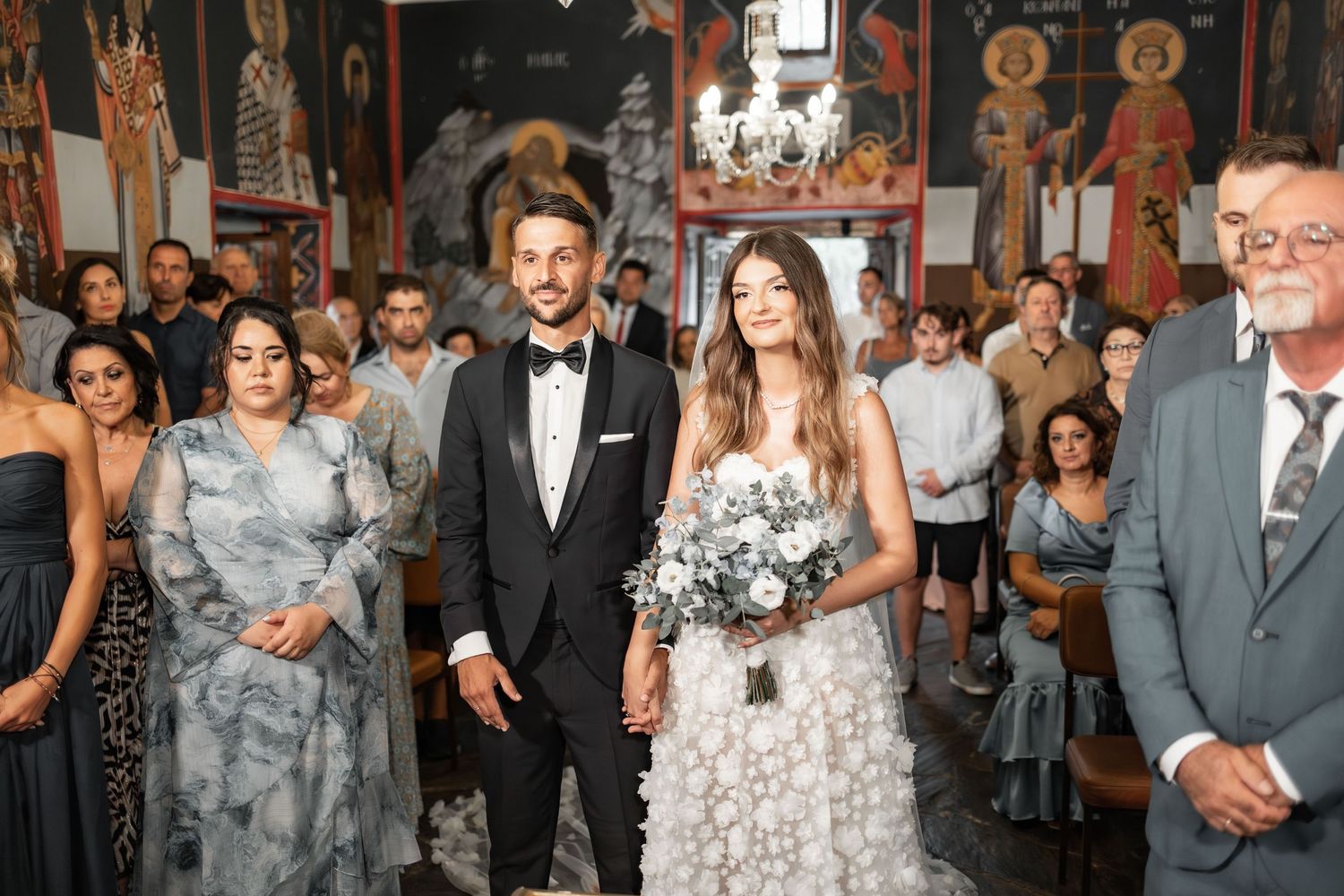 Wedding celebration inside a venue with guests in formal attire mingling.