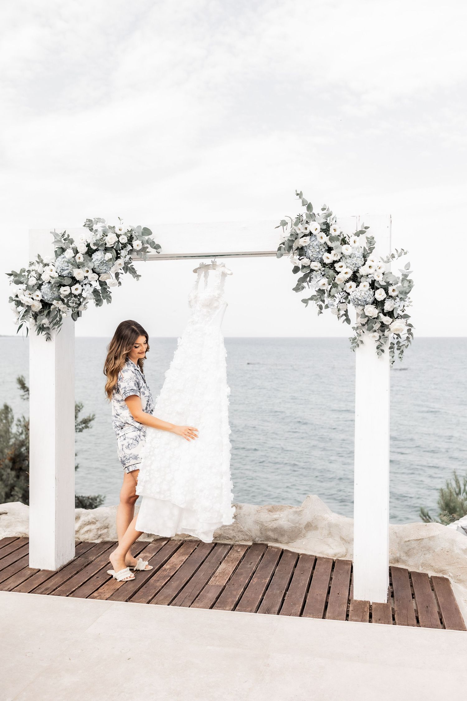 White coastal wedding venue with floral arrangements overlooking the ocean.