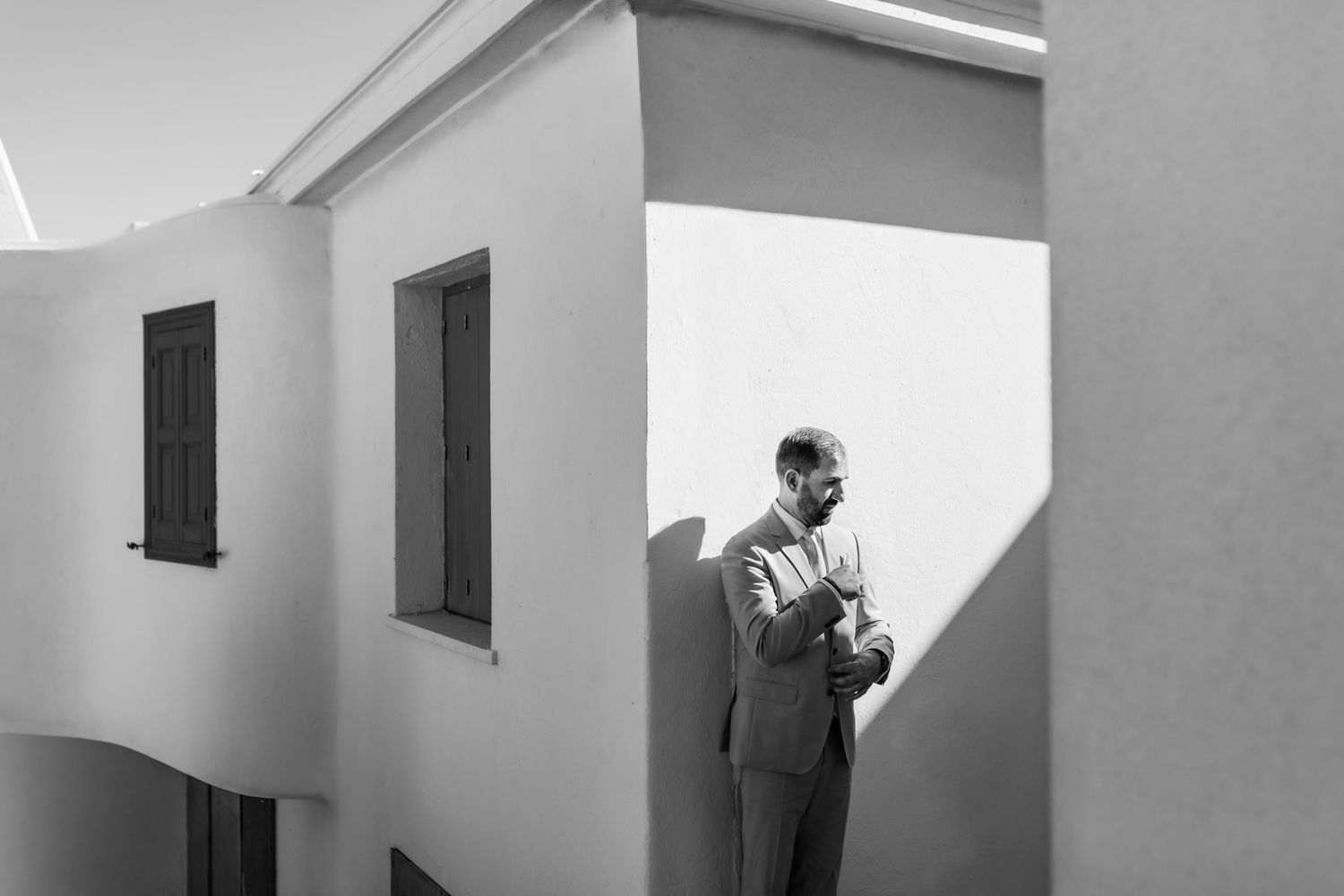 Black and white architectural wedding photo with dramatic shadows and light.