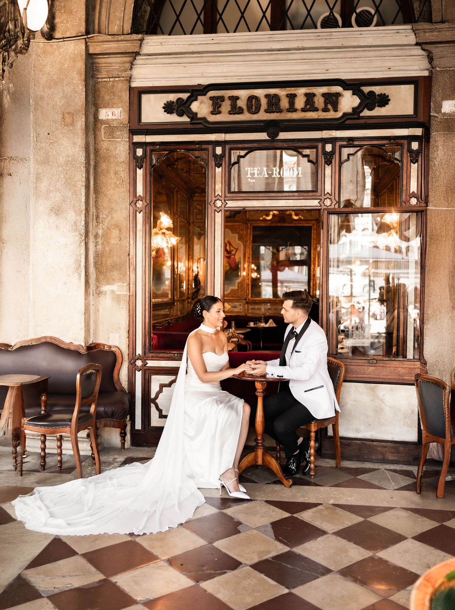 Wedding couple poses at the iconic Florian cafe in Venice with its elegant checkered floors.