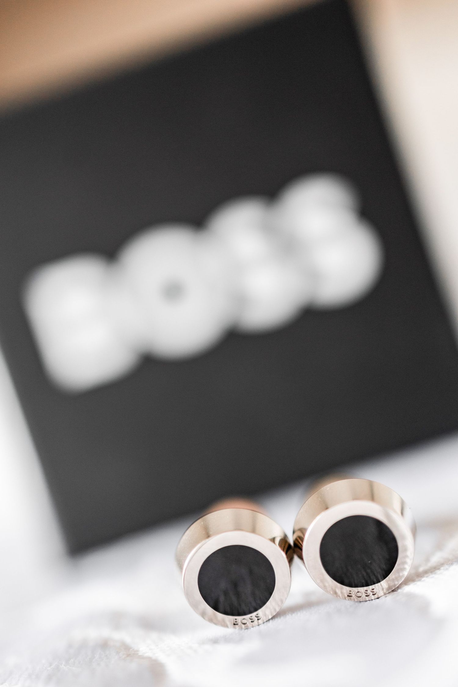 Close-up view of elegant wedding rings nestled in soft white fabric with blurred background.