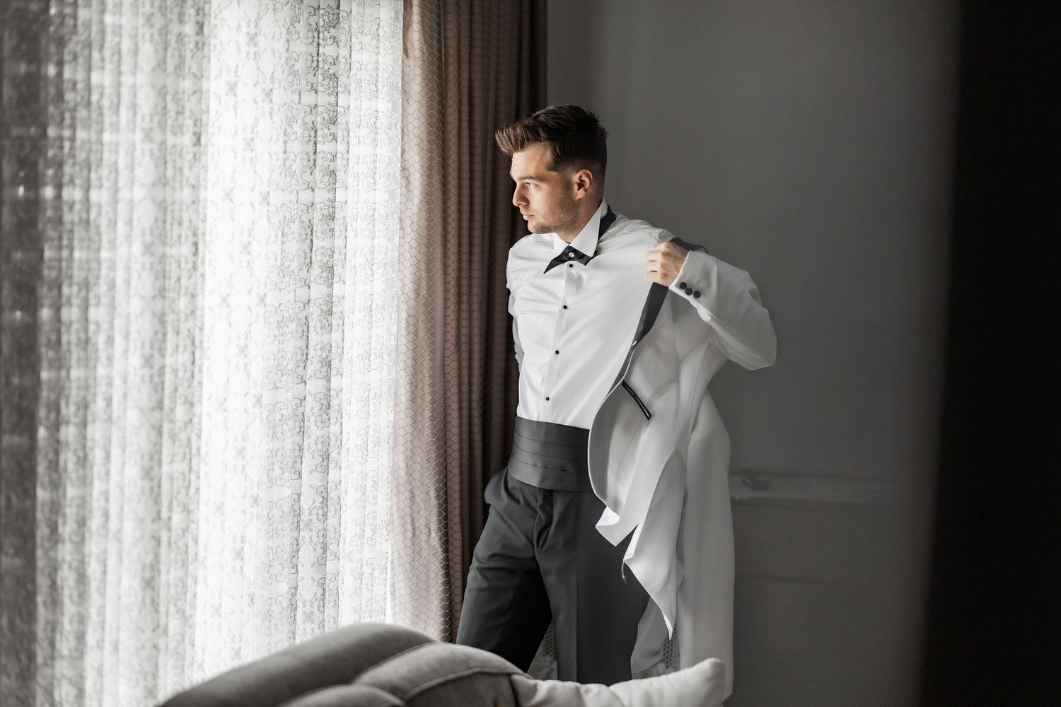 Elegant getting ready sequence showing formal wear preparation in natural window light.