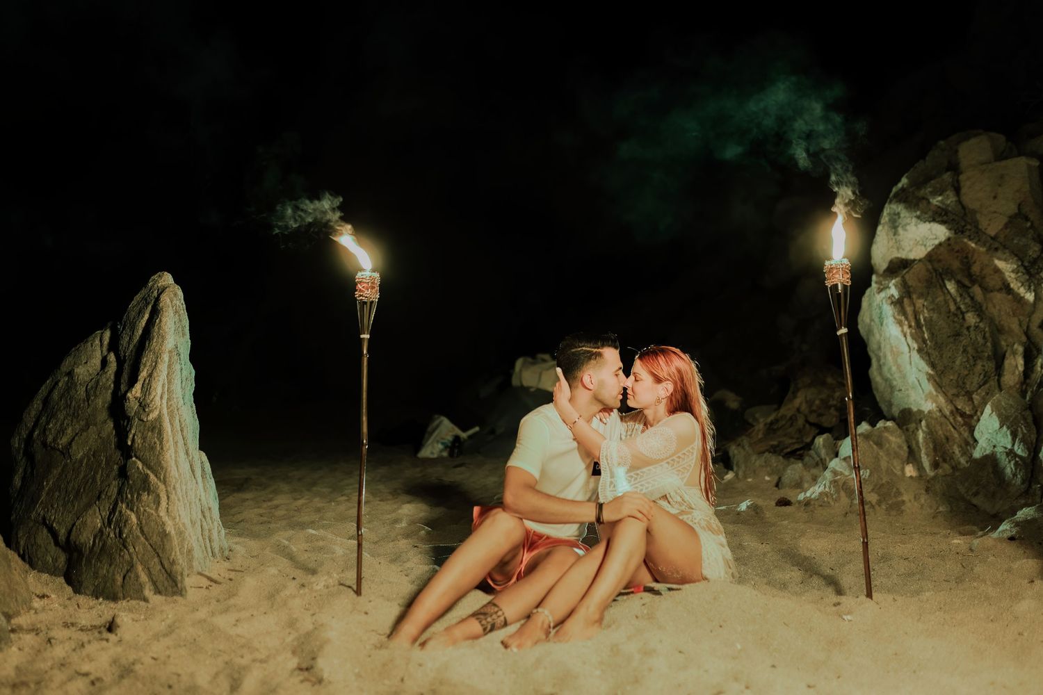 A series of nighttime photos showing people sitting on rocks near a dimly lit path in a natural outdoor setting.