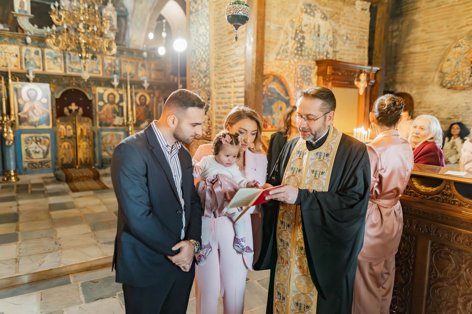 A couple shares an intimate moment during a wedding ceremony in a rustic stone church with ornate decor.