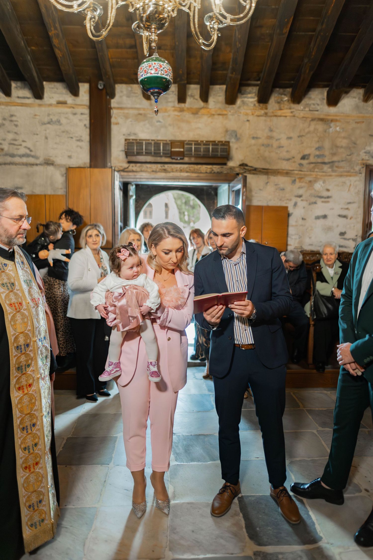 Wedding guests learn dance moves in a rustic venue with stone walls and wooden beams during a group dance lesson.