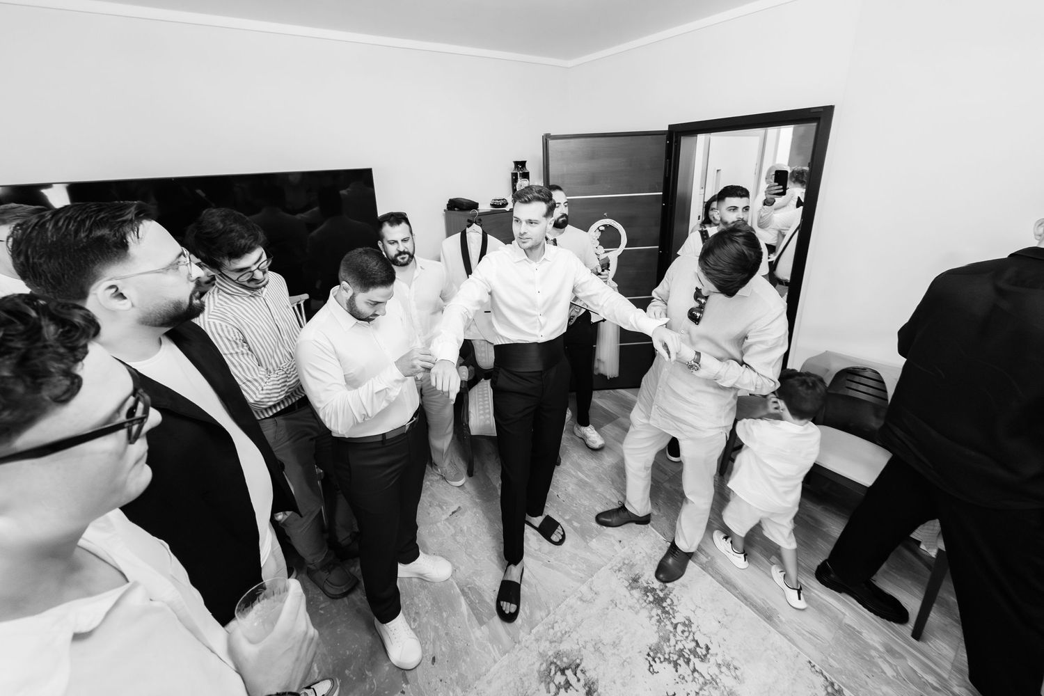 Black and white candid shots of wedding guests dancing and celebrating at reception.