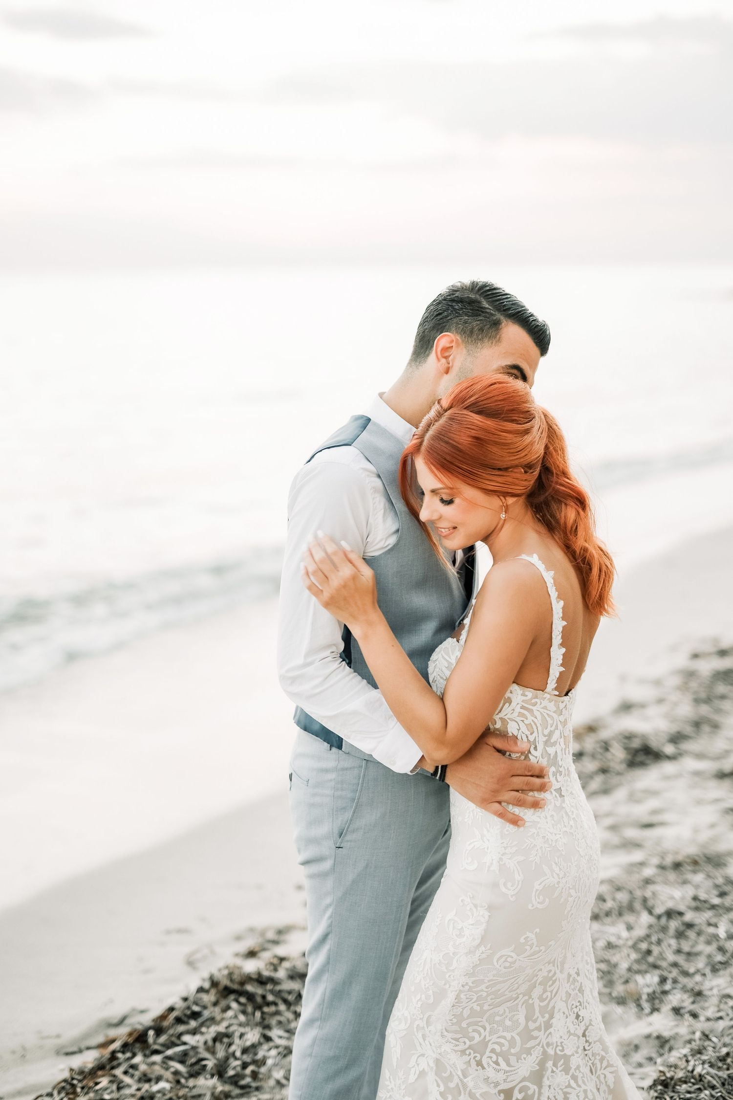 A romantic beach wedding couple embraces on the shoreline in a dreamy, ethereal photoshoot sequence.