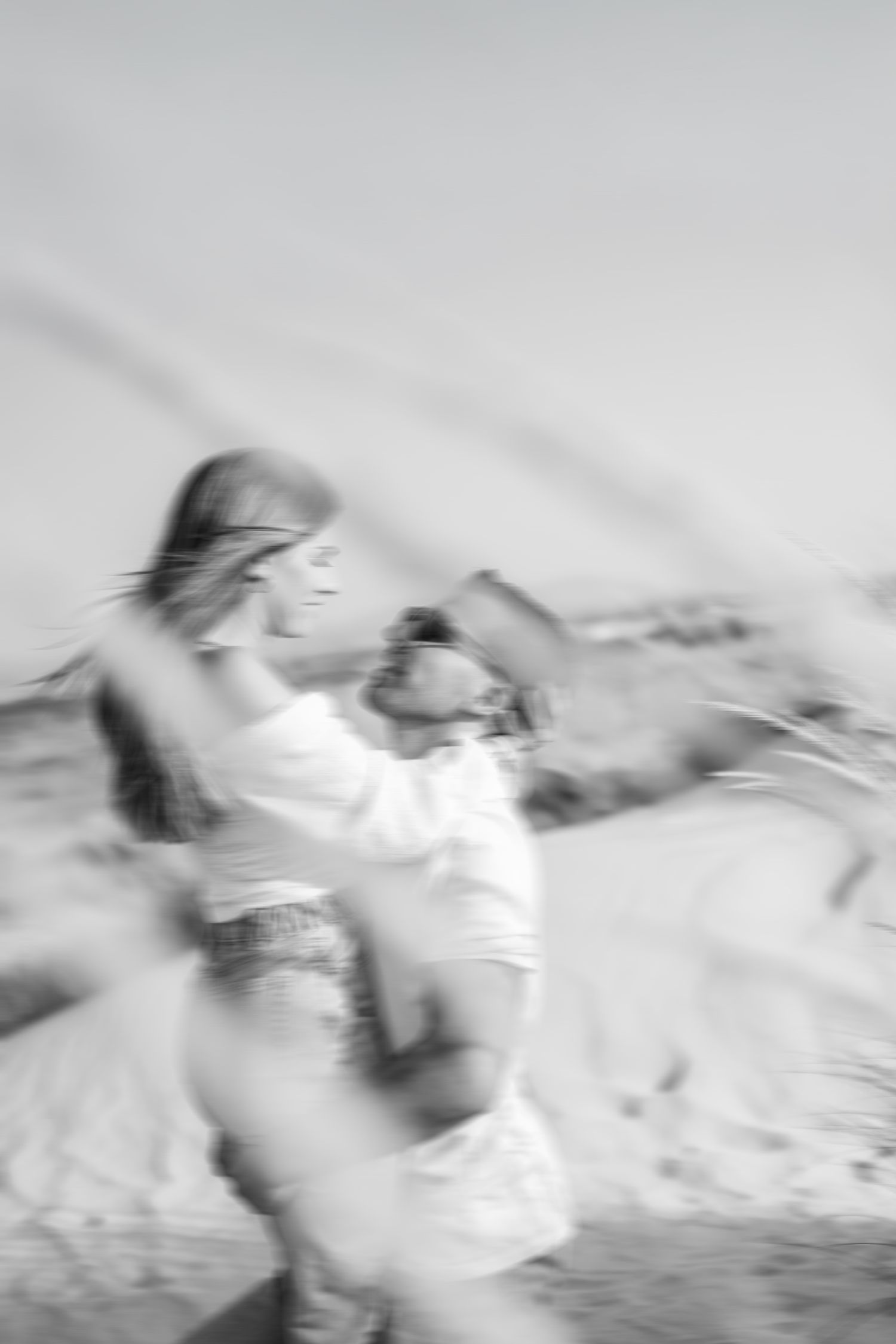 Artistic black and white motion blur photograph of a person swimming through water with dynamic movement.