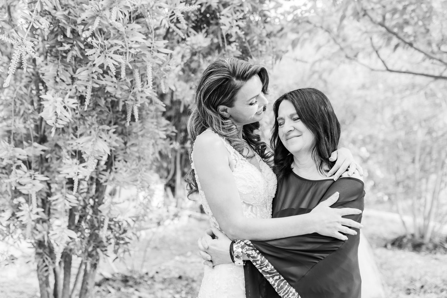Black and white photo of joyful wedding party moments in an outdoor setting.