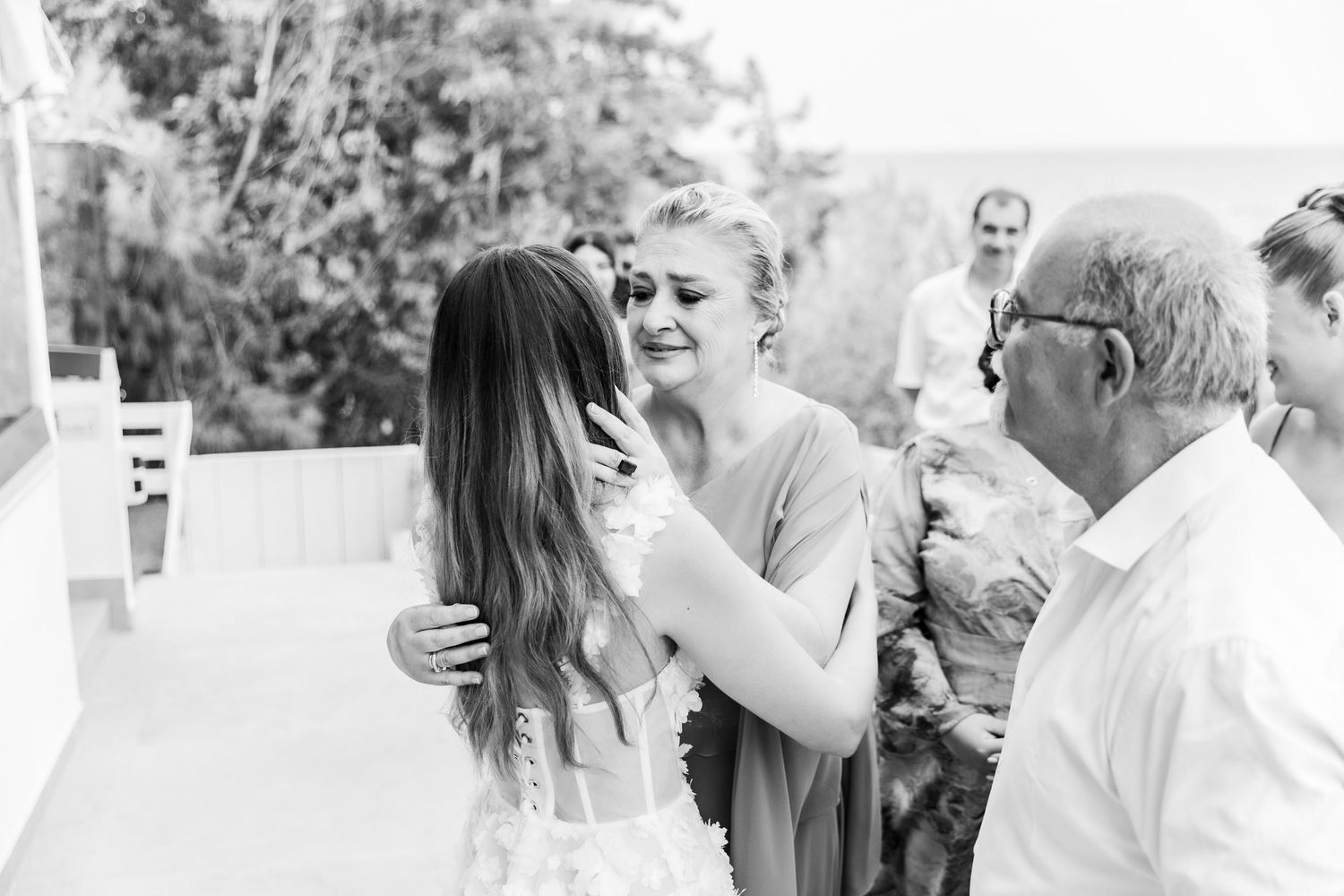 Wedding party celebrates with joyful emotions in black and white photography.