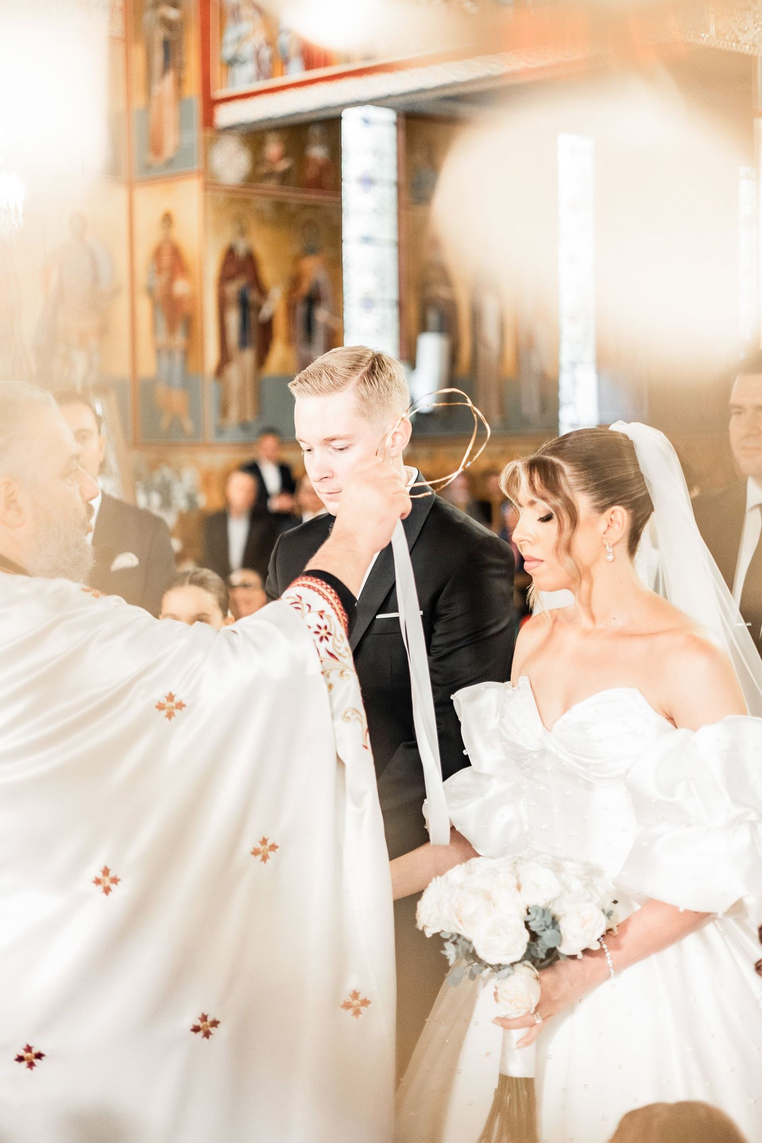 Wedding ceremony in an ornate church with soft natural lighting.