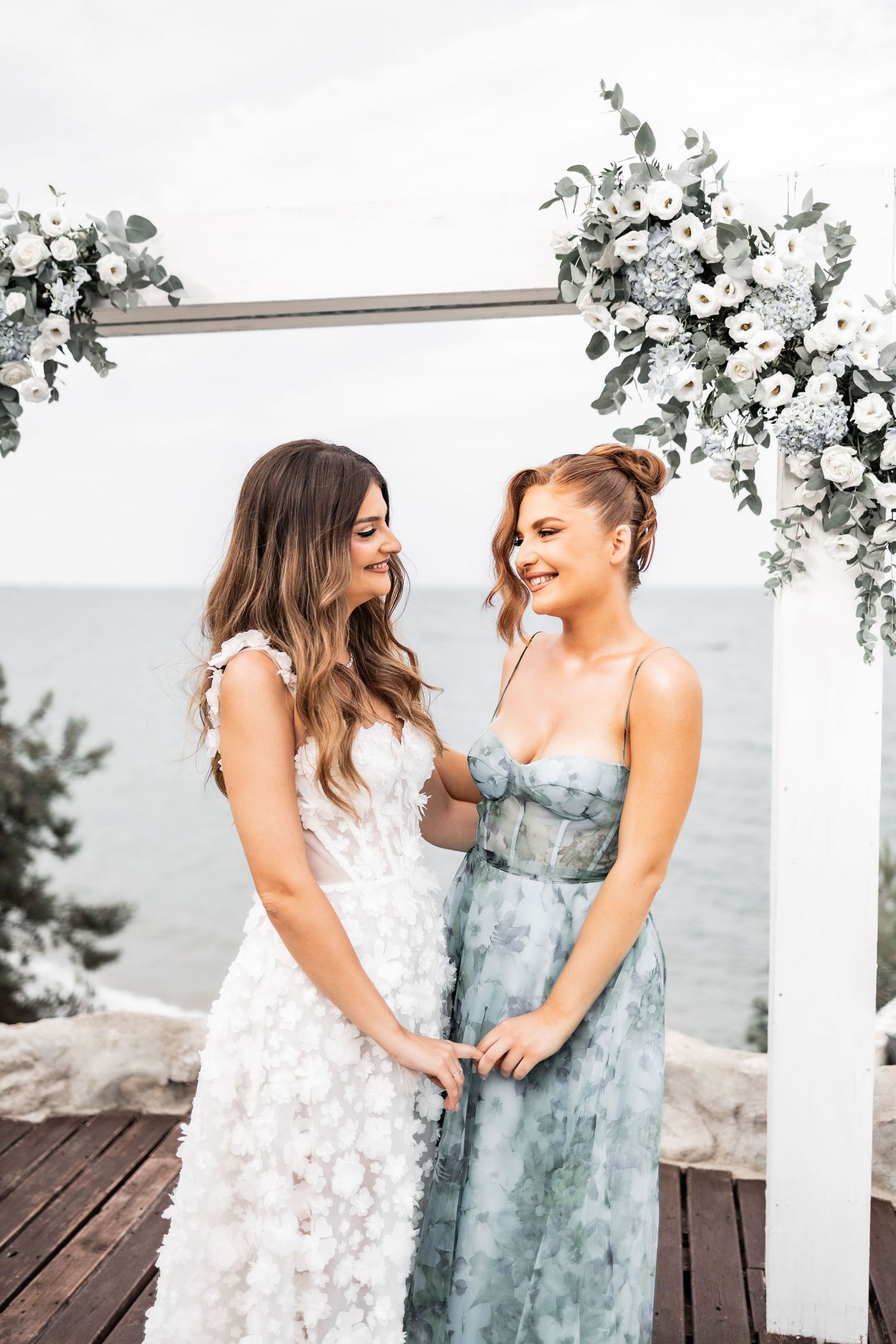 Two people share an intimate moment on a deck decorated with white flowers.
