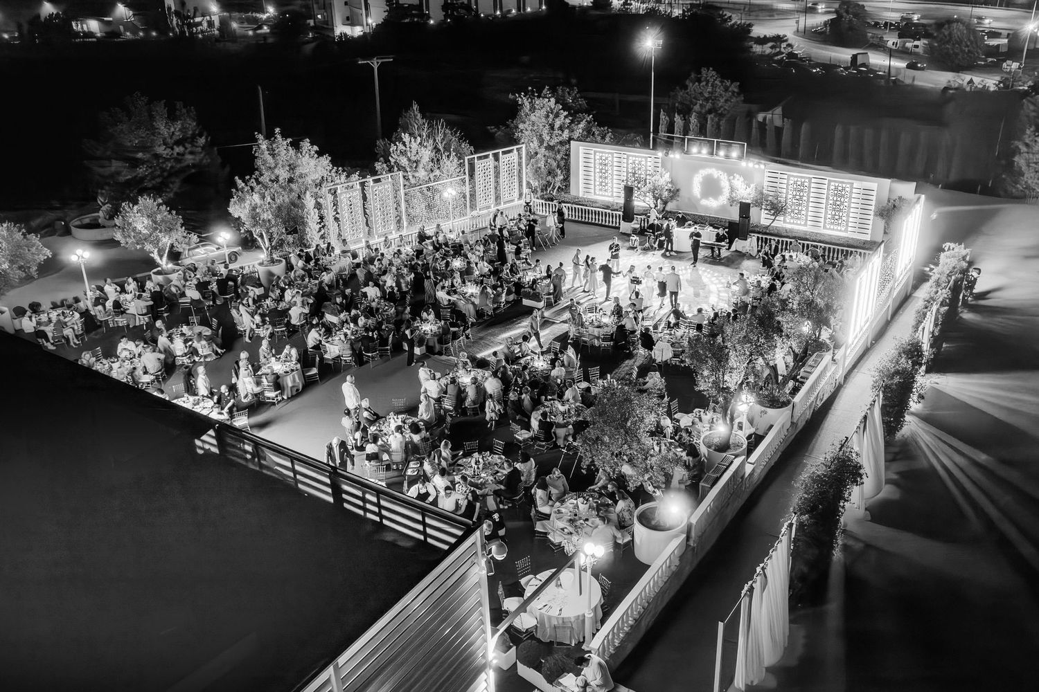 Aerial view of a wedding reception venue with guests seated at decorated tables.