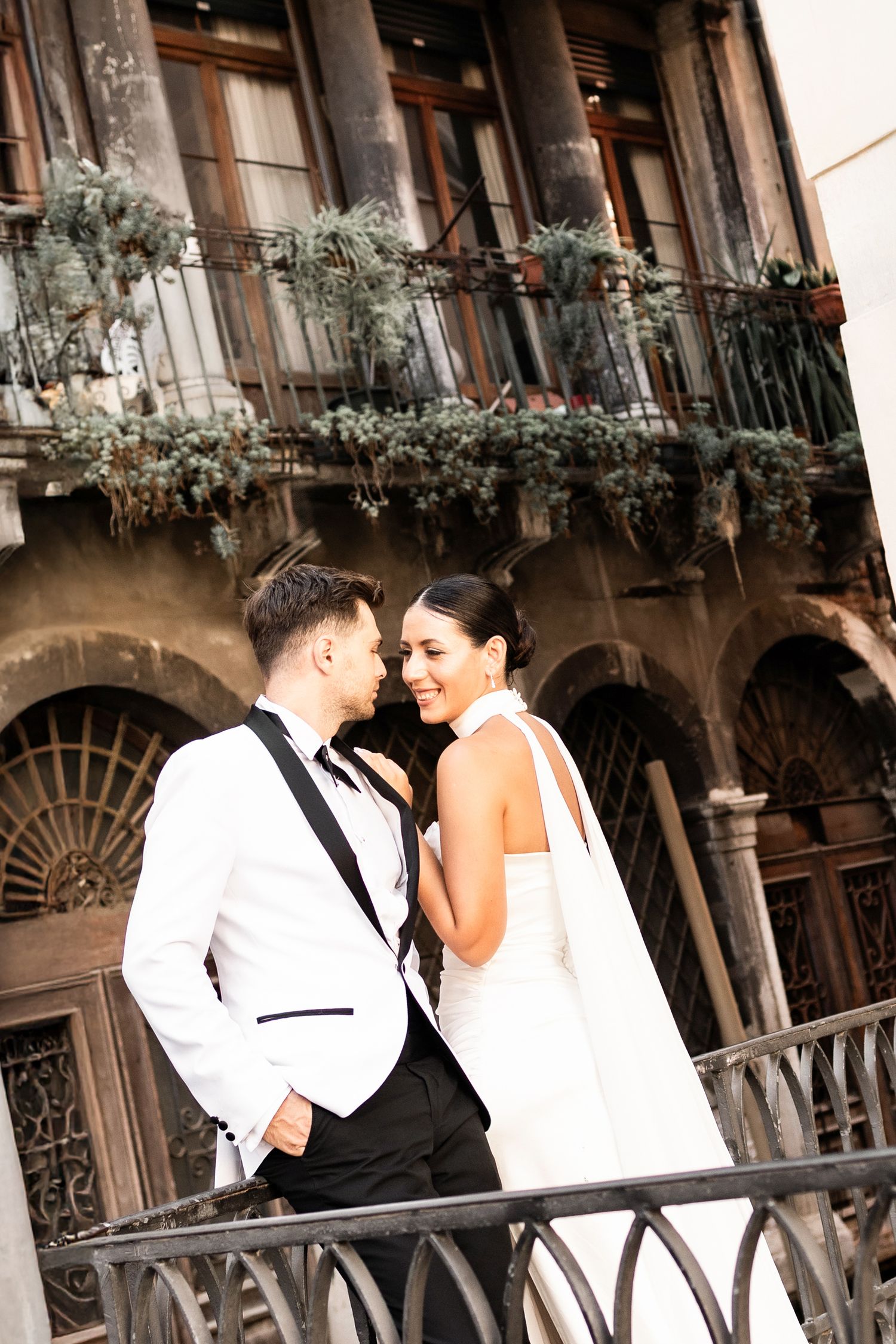 Romantic wedding portraits along a historic Venetian balcony with flower boxes.