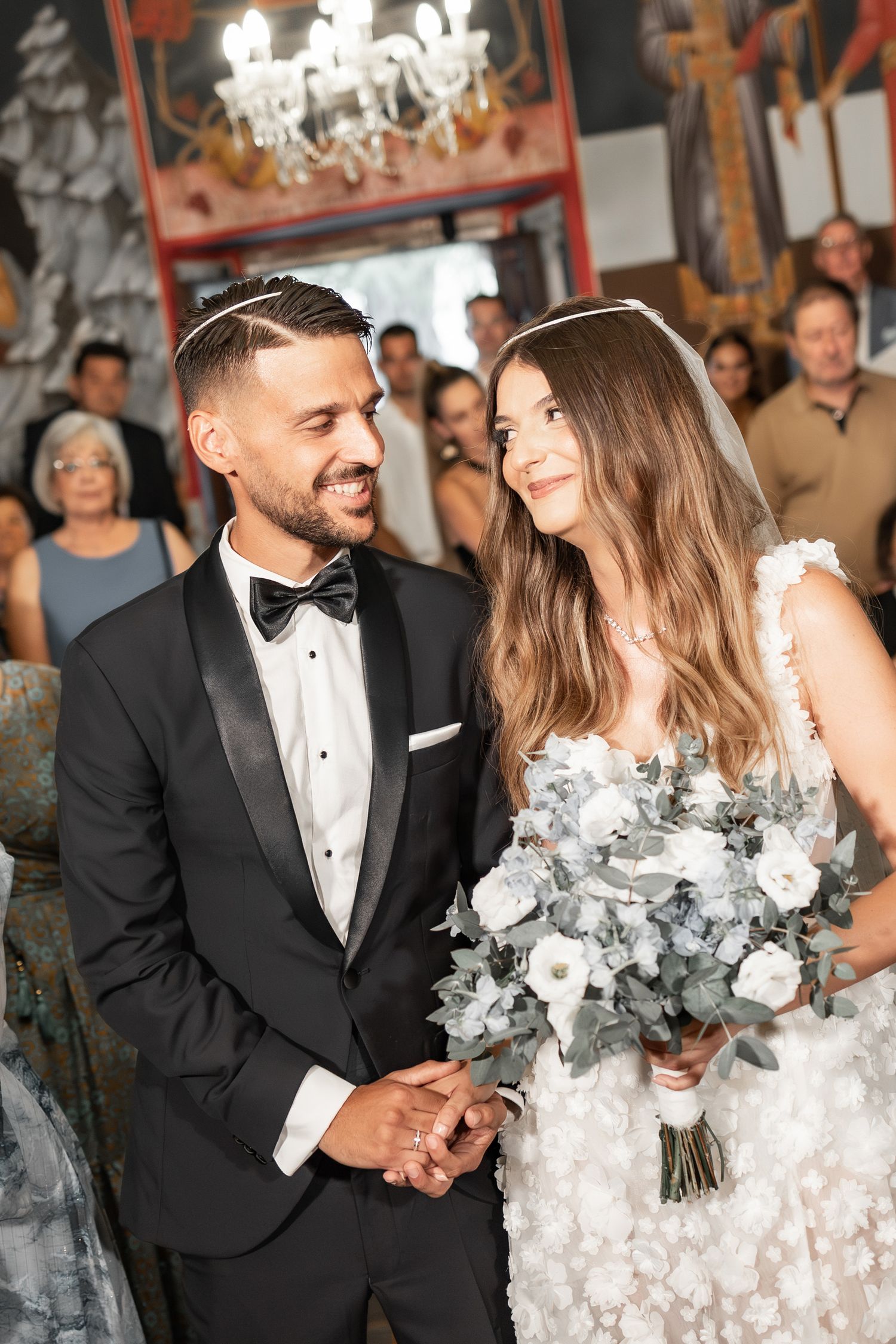 Newlyweds share intimate moments in an ornately decorated church setting.