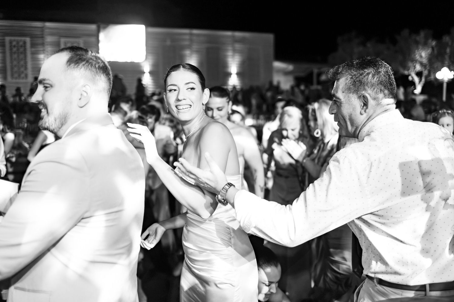 Wedding guests enjoying themselves at a lively dance party in black and white.