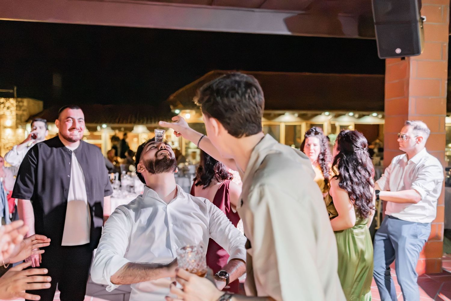 Guests dancing and socializing at an outdoor evening wedding reception party.