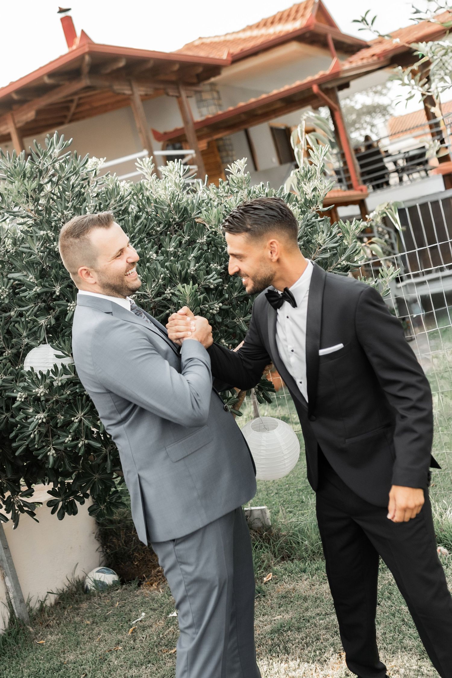 Two wedding party members share a lighthearted moment in formal attire.