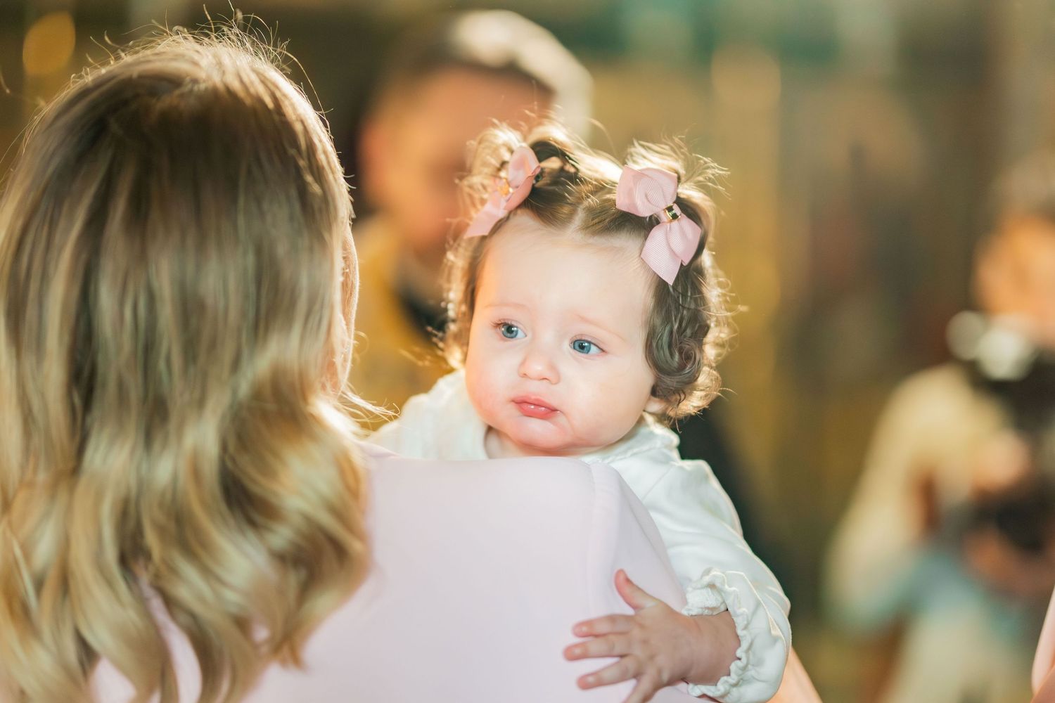 A series of candid shots showing tender moments between a parent and baby at a social gathering.
