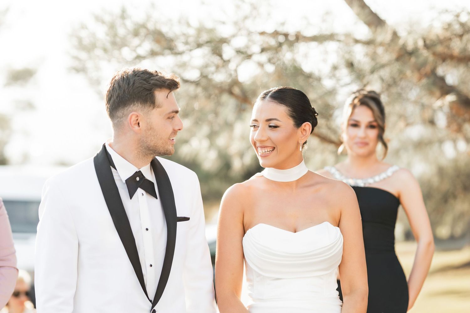 Candid moments shared between wedding party members during an outdoor celebration.