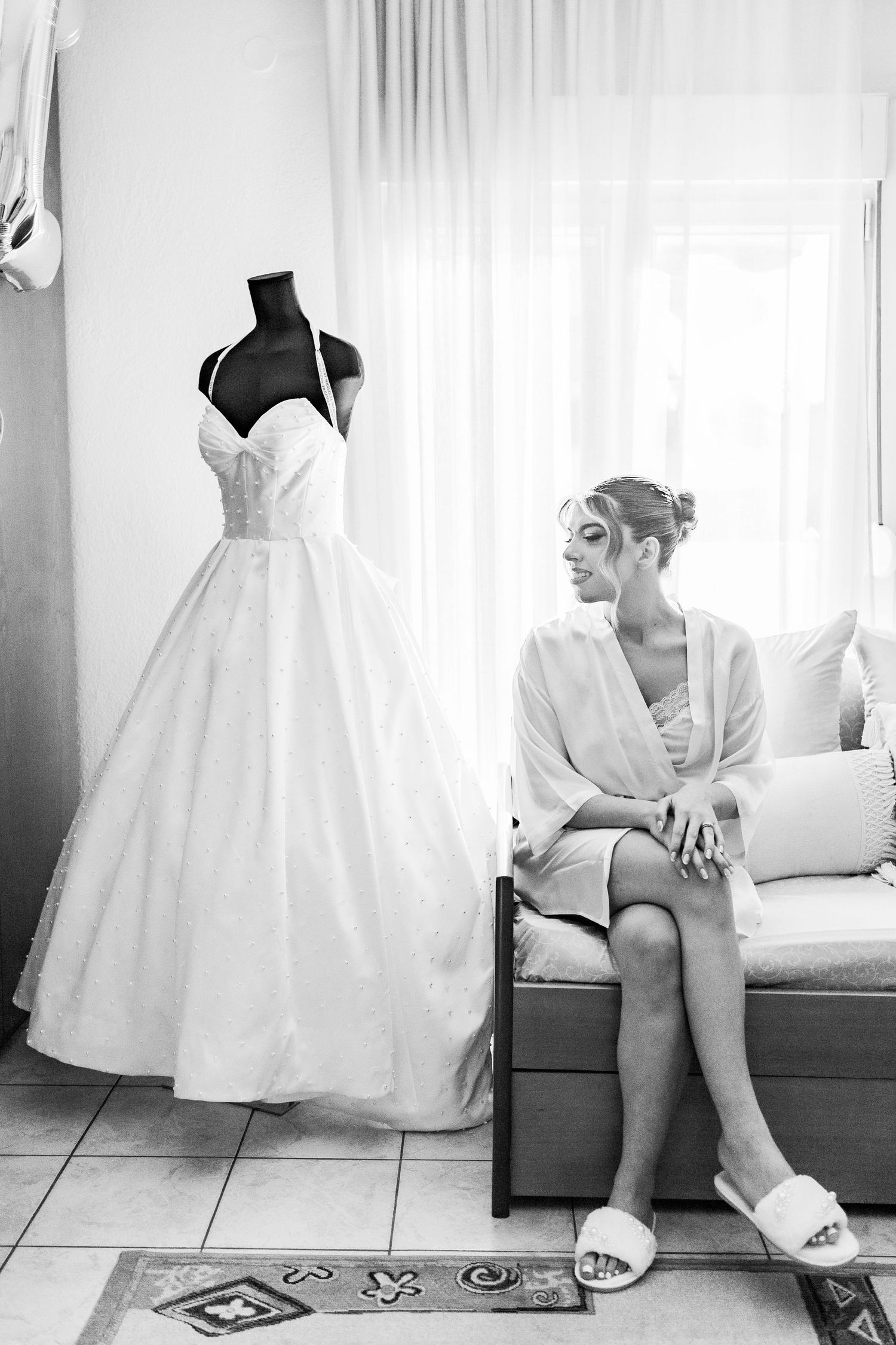 Artistic black and white photos of wedding dress preparation moments.