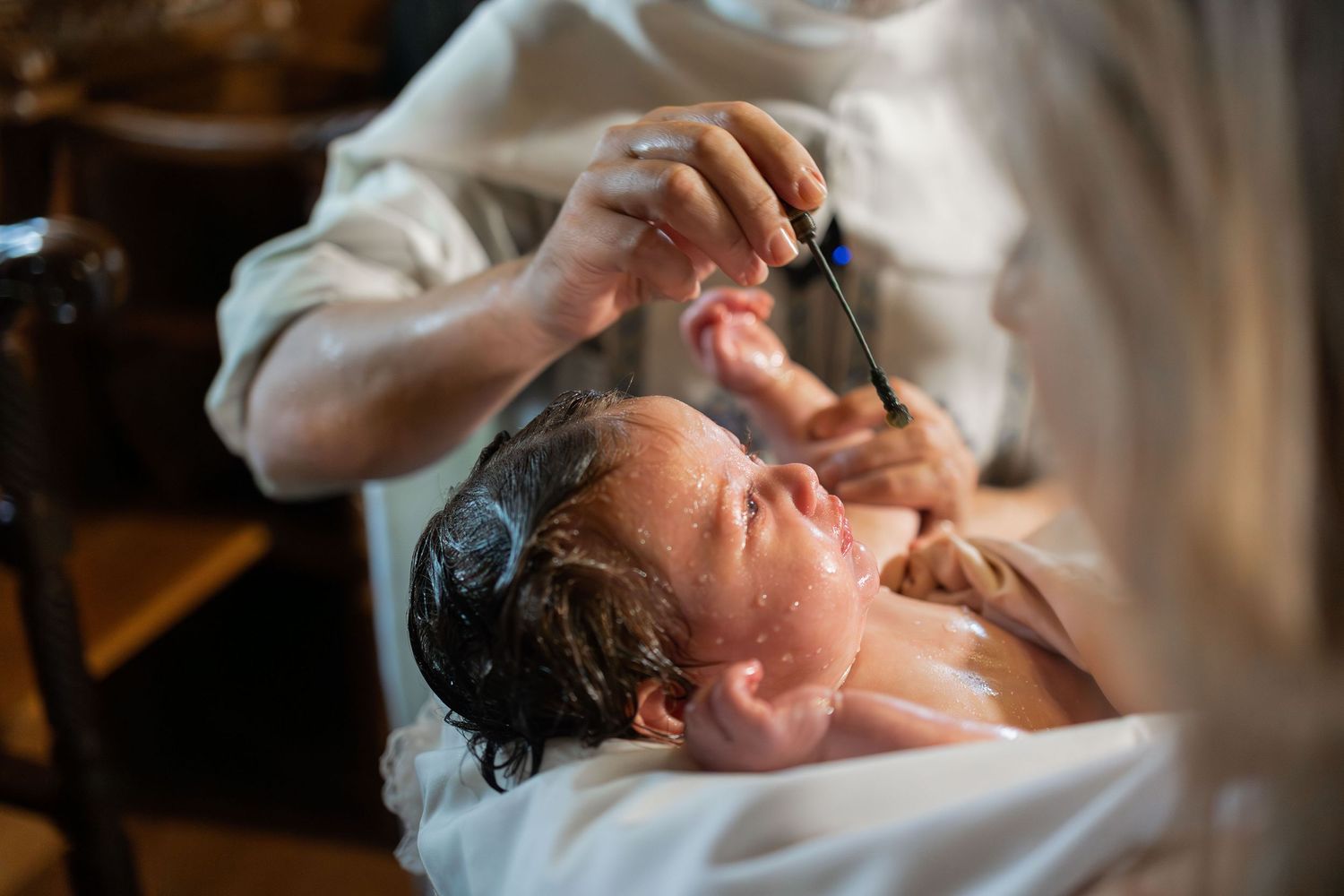 Professional barber applies shaving cream and performs traditional straight razor shave service at upscale barbershop.