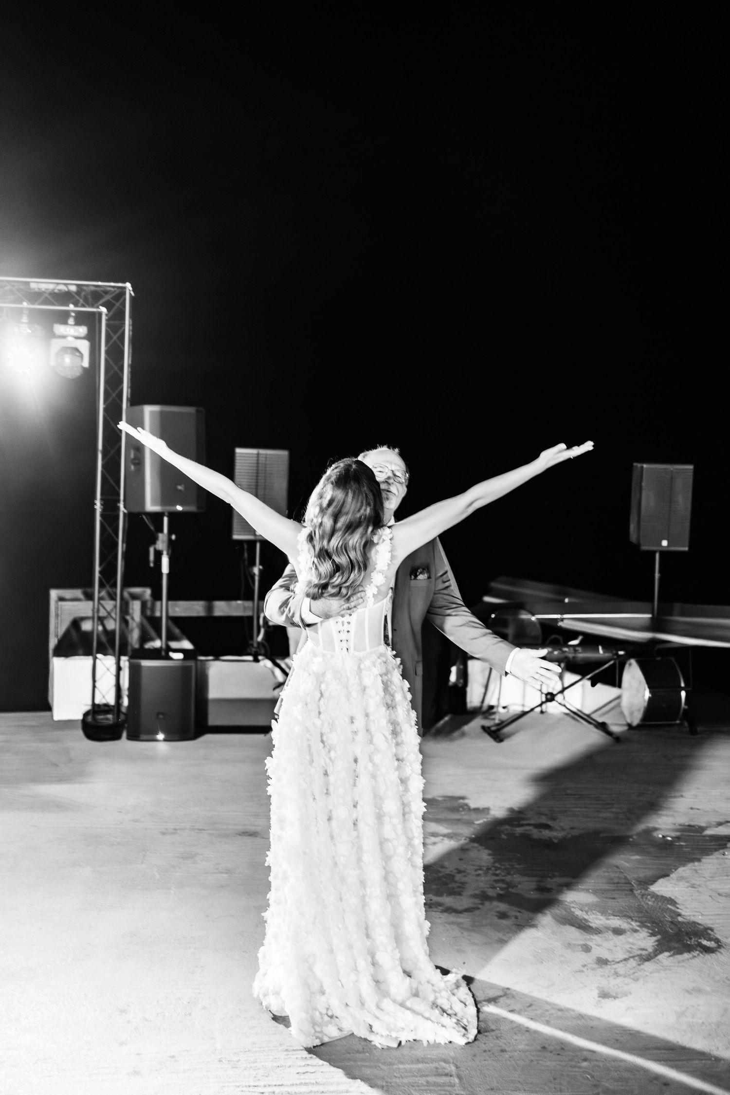 Dramatic black and white photos of bride dancing with arms outstretched.
