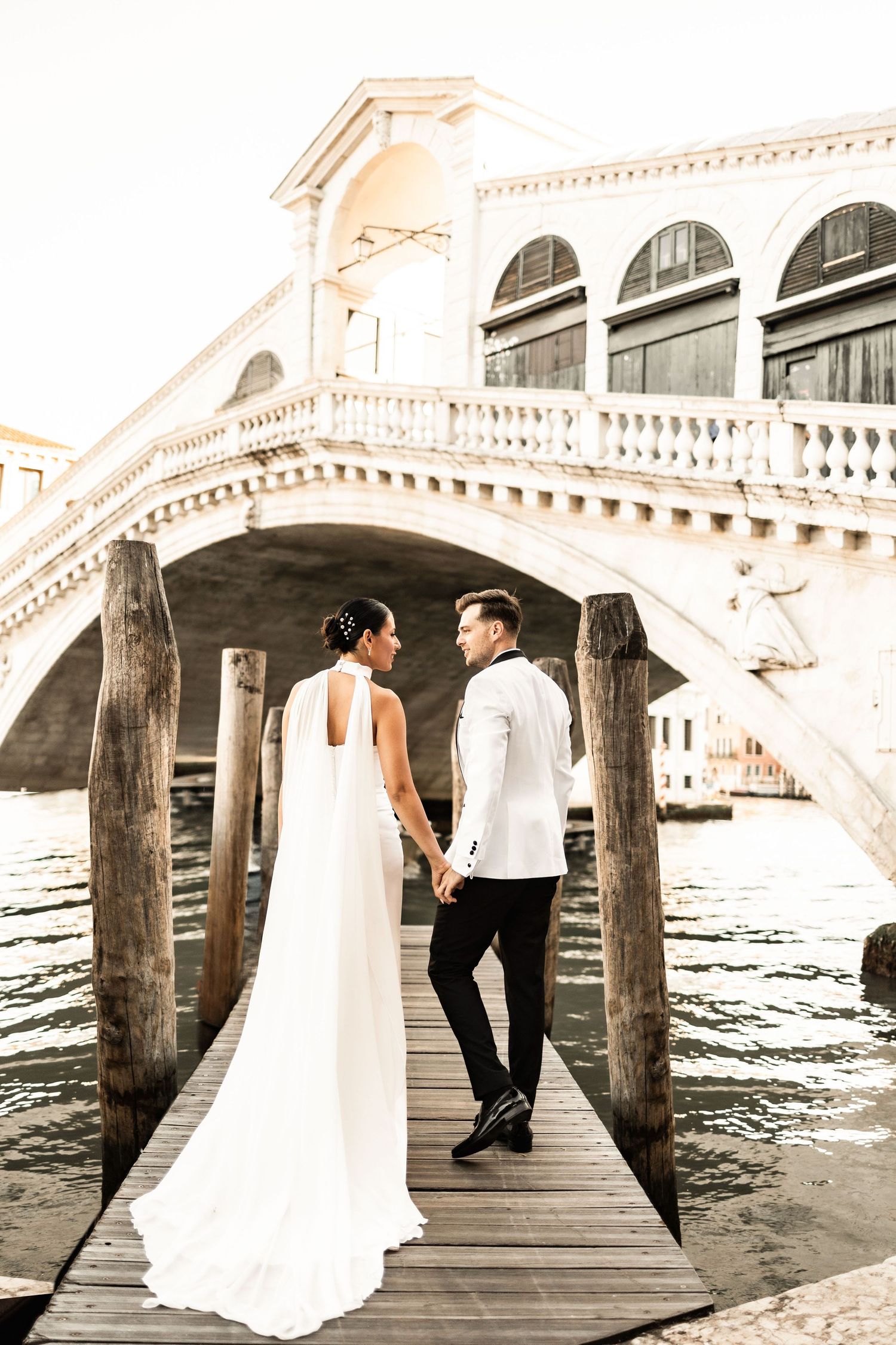 Romantic photoshoot under the arches of Venice's Rialto Bridge.