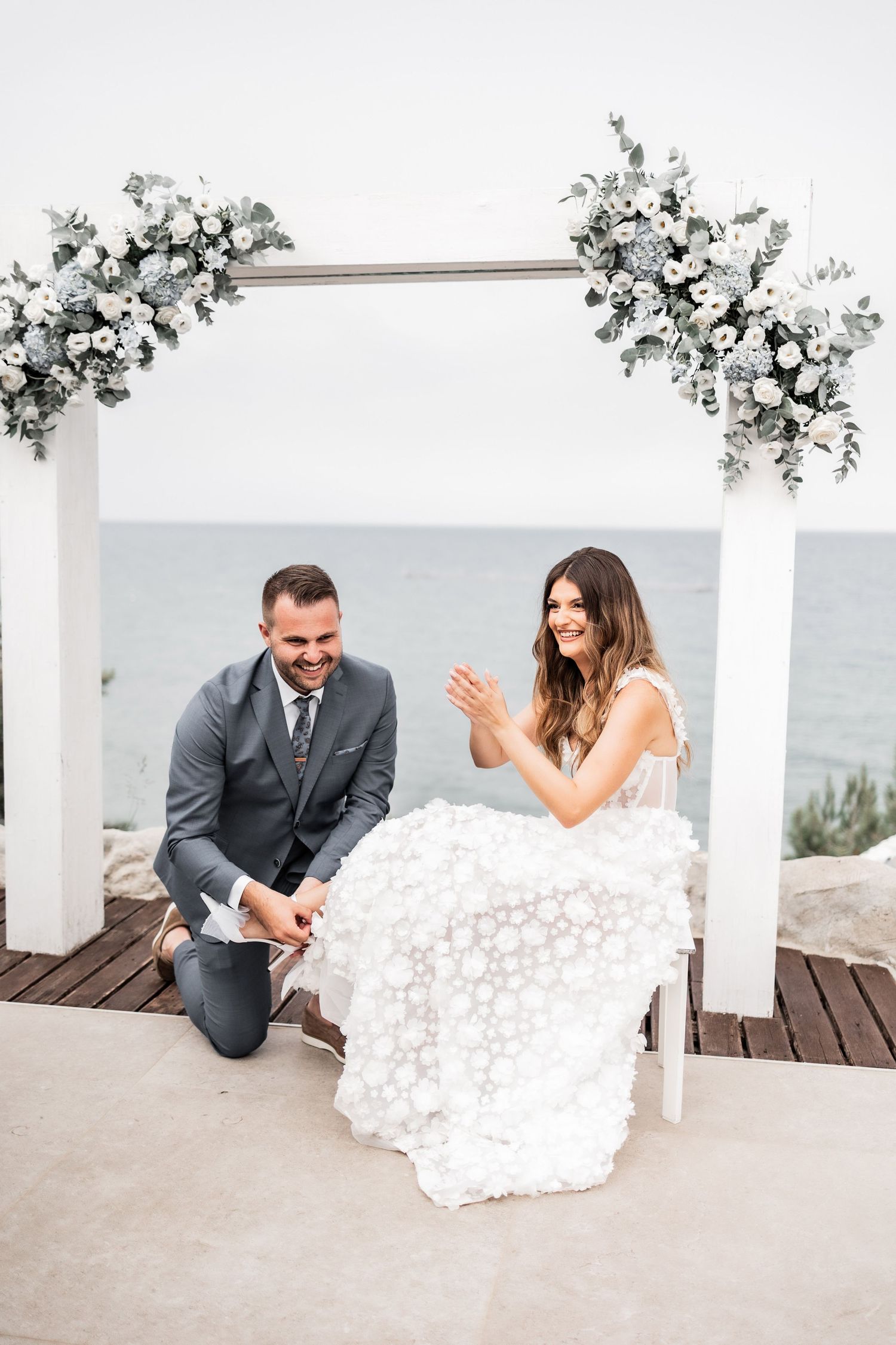 Candid wedding moments captured on an oceanview deck with floral decorations.