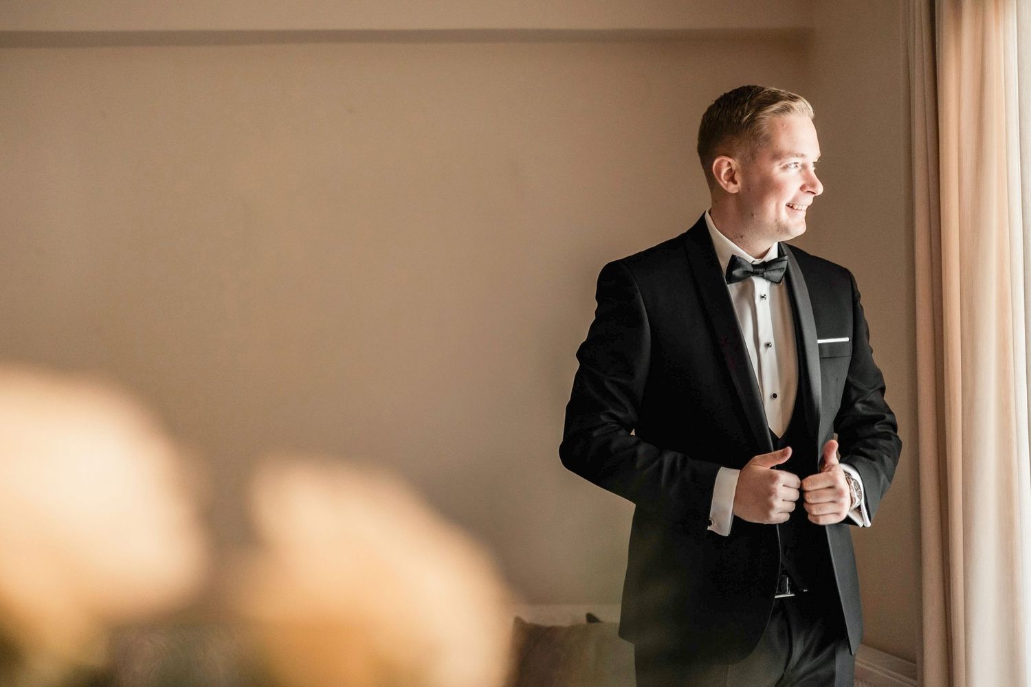 Sequence of a groom adjusting his tie and suit before the wedding ceremony.
