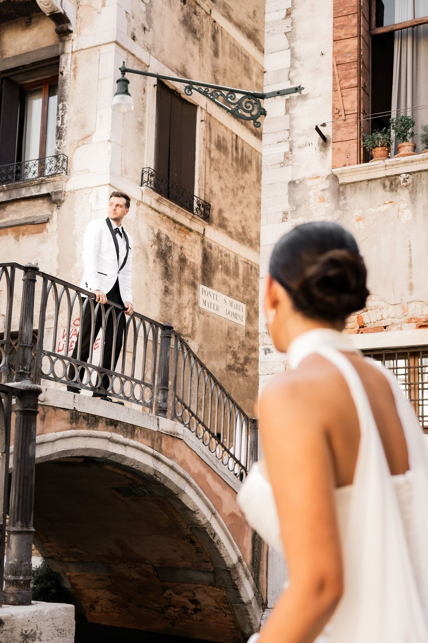 A romantic wedding photo session on a historic Venice bridge with ornate stone architecture.