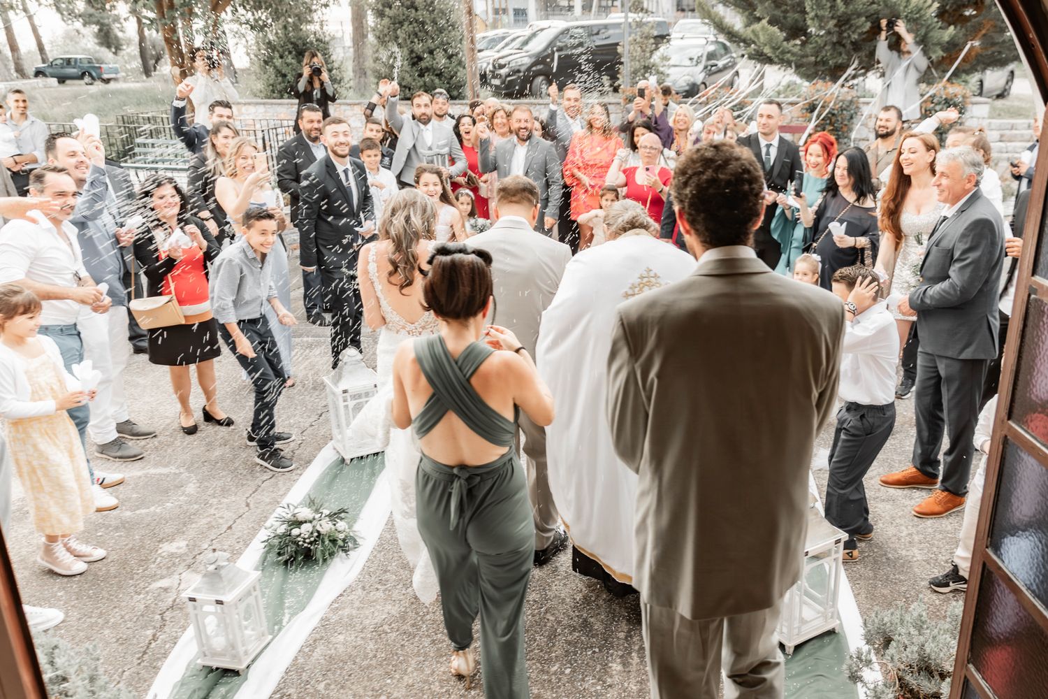 Wedding guests throw rice and celebrate outside during the post-ceremony festivities.