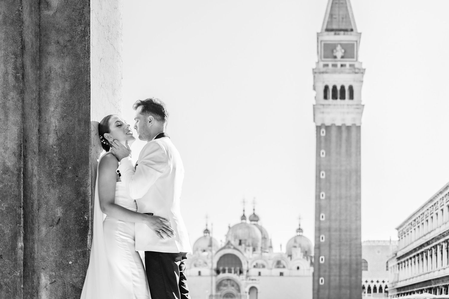 A romantic moment captured in Venice with St Mark's Basilica and bell tower in the background.