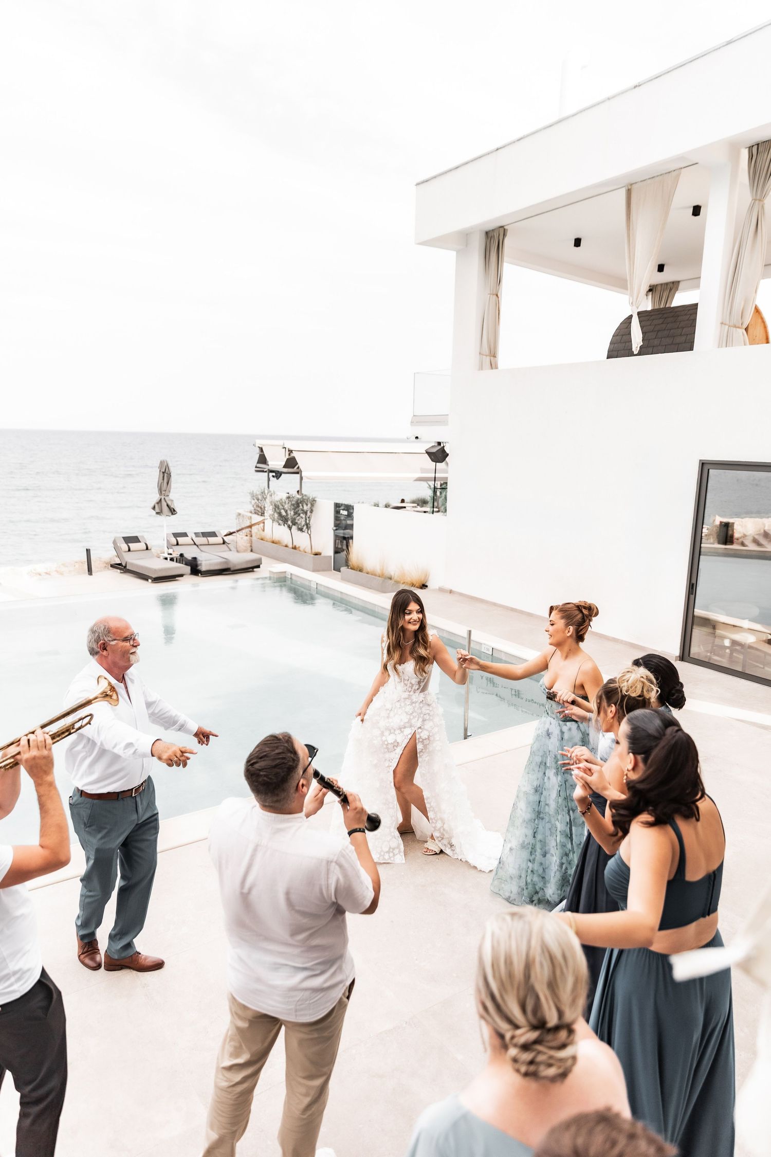 Wedding guests dance and celebrate at an outdoor reception venue.