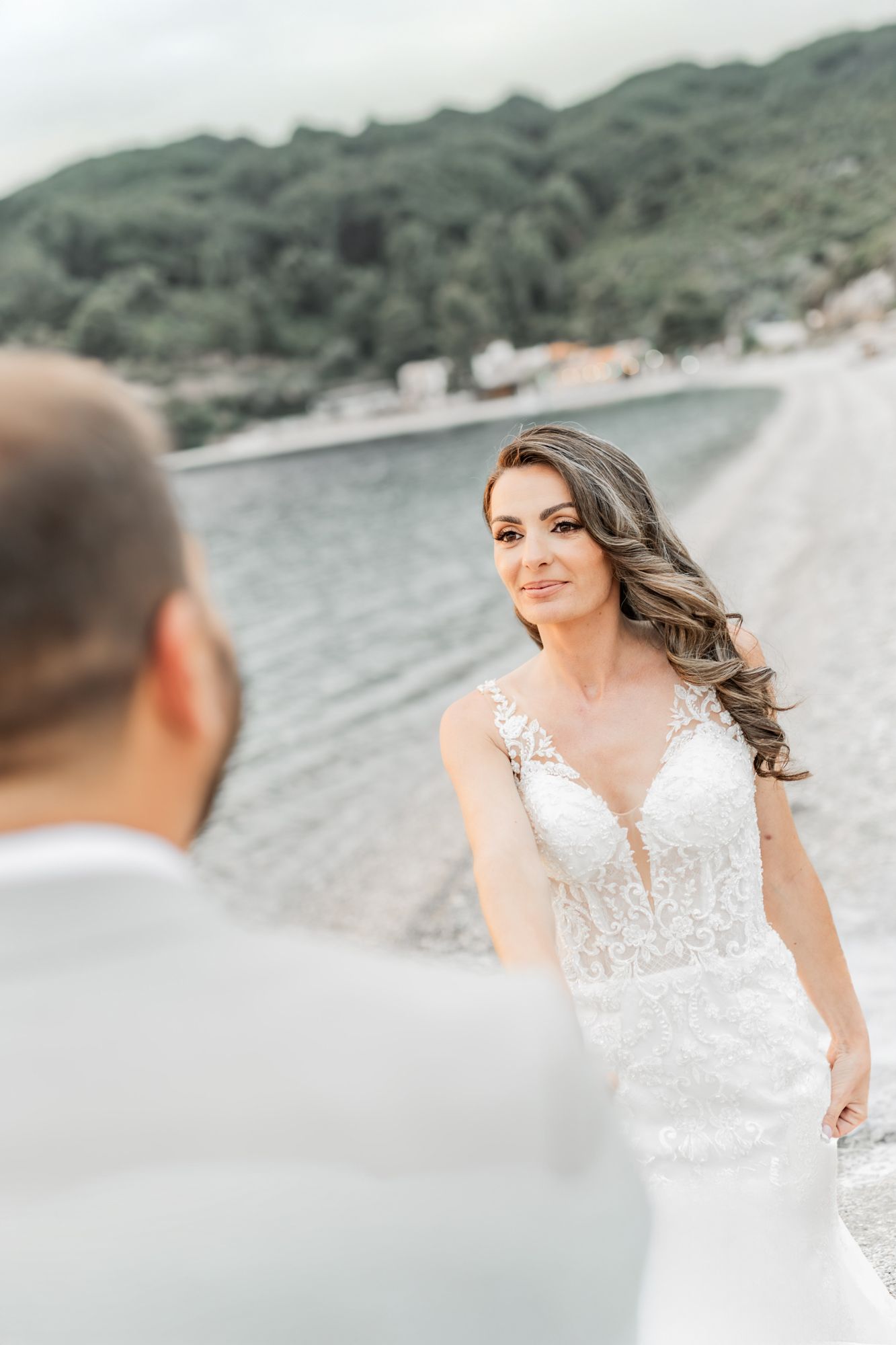 A scenic beachside wedding photoshoot with a lace wedding dress against a coastal backdrop.