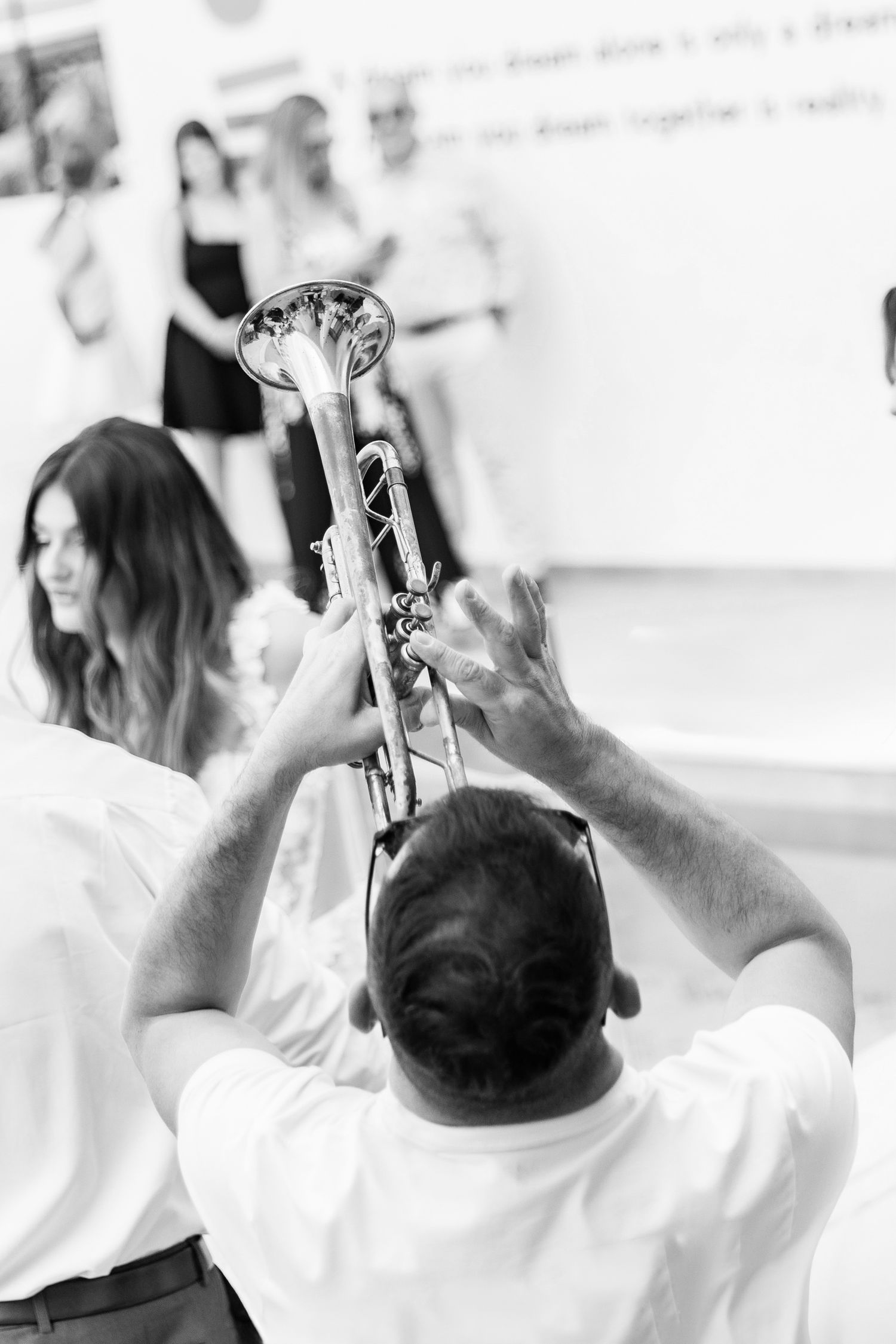 Wedding guests raise their phones to capture special moments in black and white.