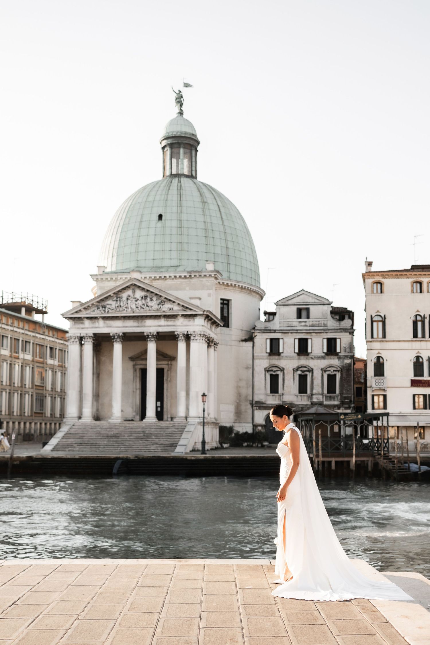 Architectural view of a grand domed church and buildings along Venice's waterfront.